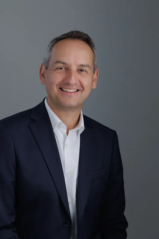 Portrait professionnel d’un dirigeant d’entreprise en costume bleu réalisé en studio pour la communication corporate et LinkedIn.
