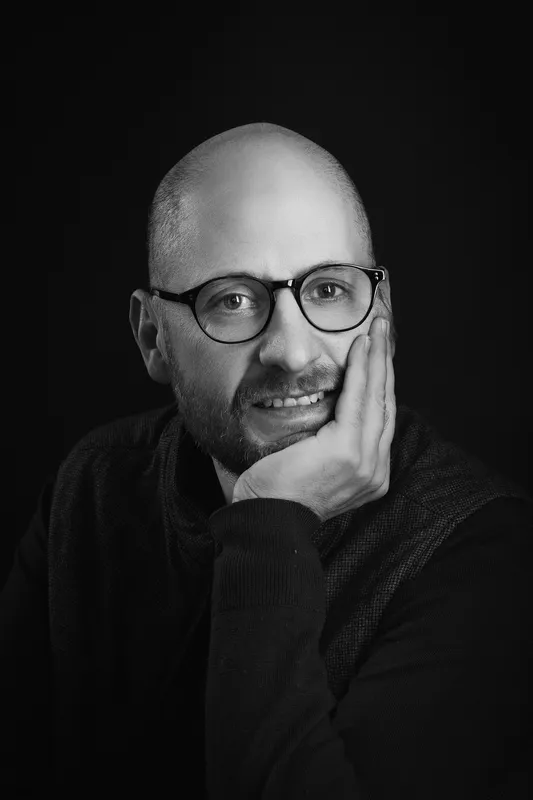 Portrait professionnel noir et blanc d’un consultant mettant en avant proximité, réflexion et accessibilité.