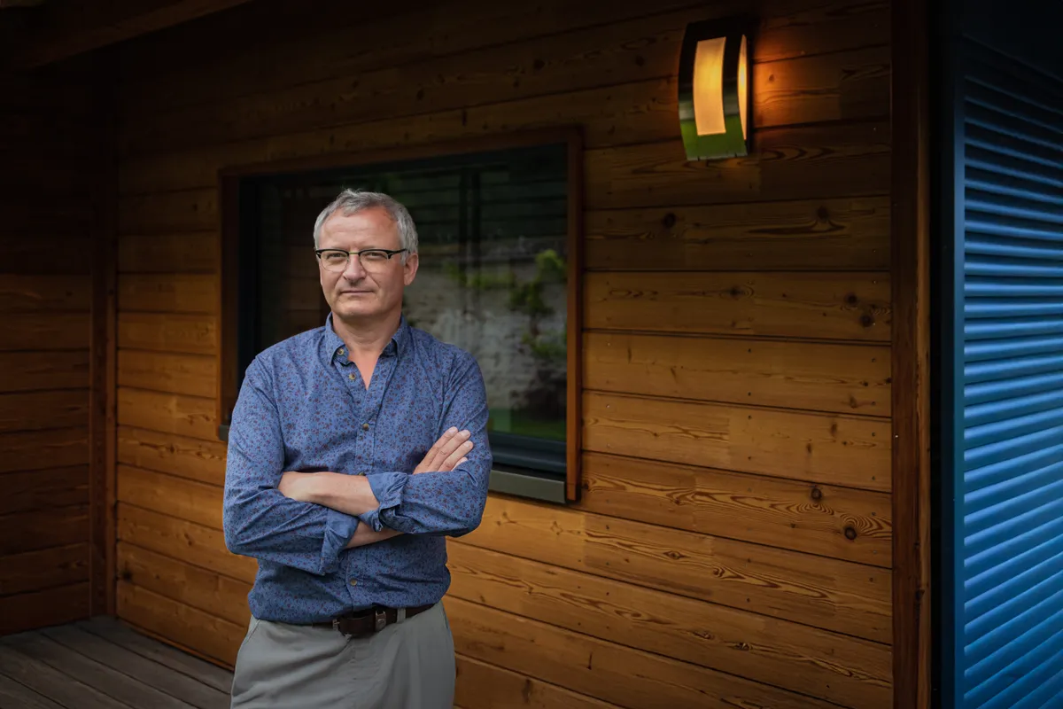 Portrait professionnel d’un entrepreneur devant son lieu d’activité pour illustrer son savoir-faire et son environnement de travail.