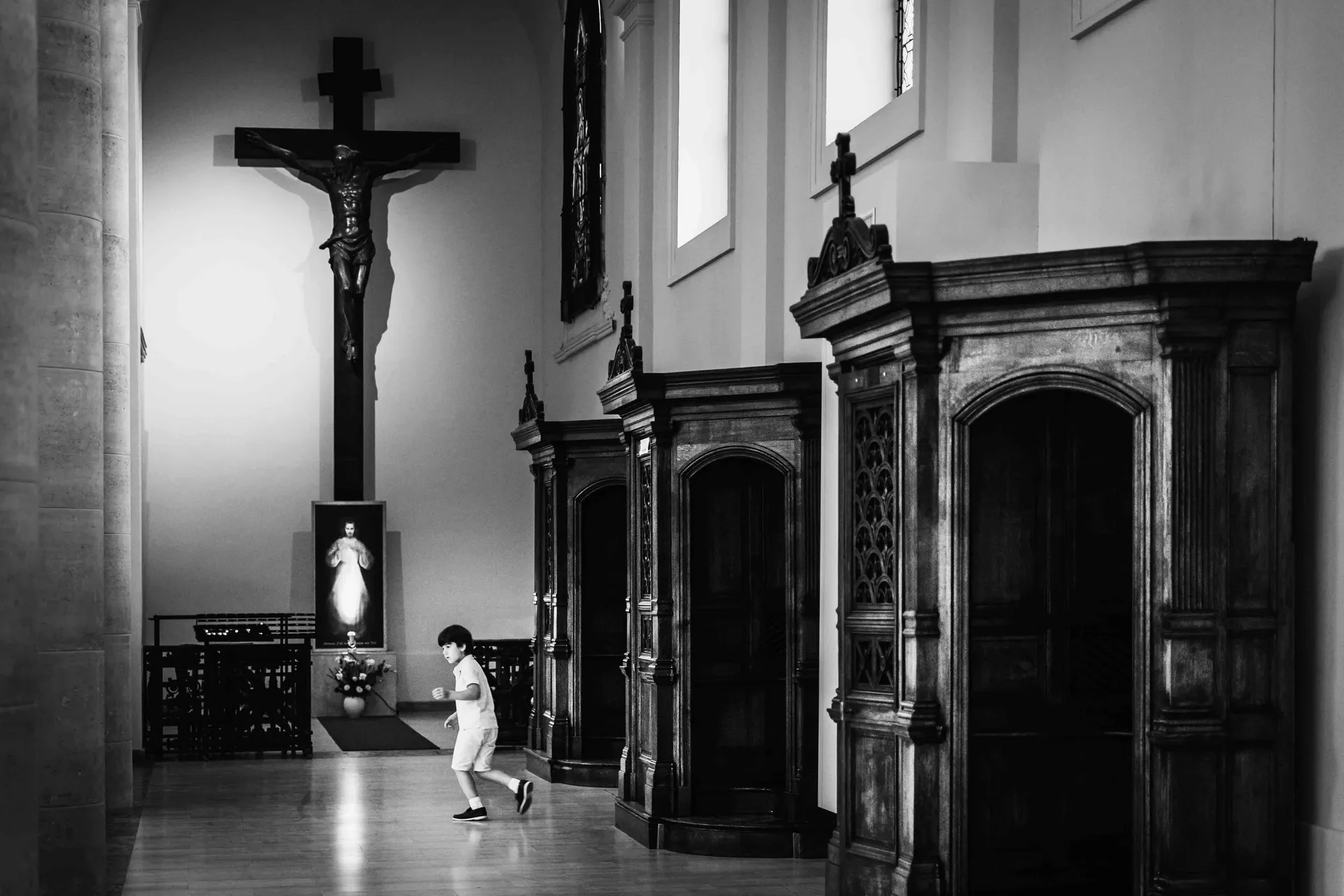 Enfant se promenant seul dans les allées d'une église à Paris avant la cérémonie de baptême