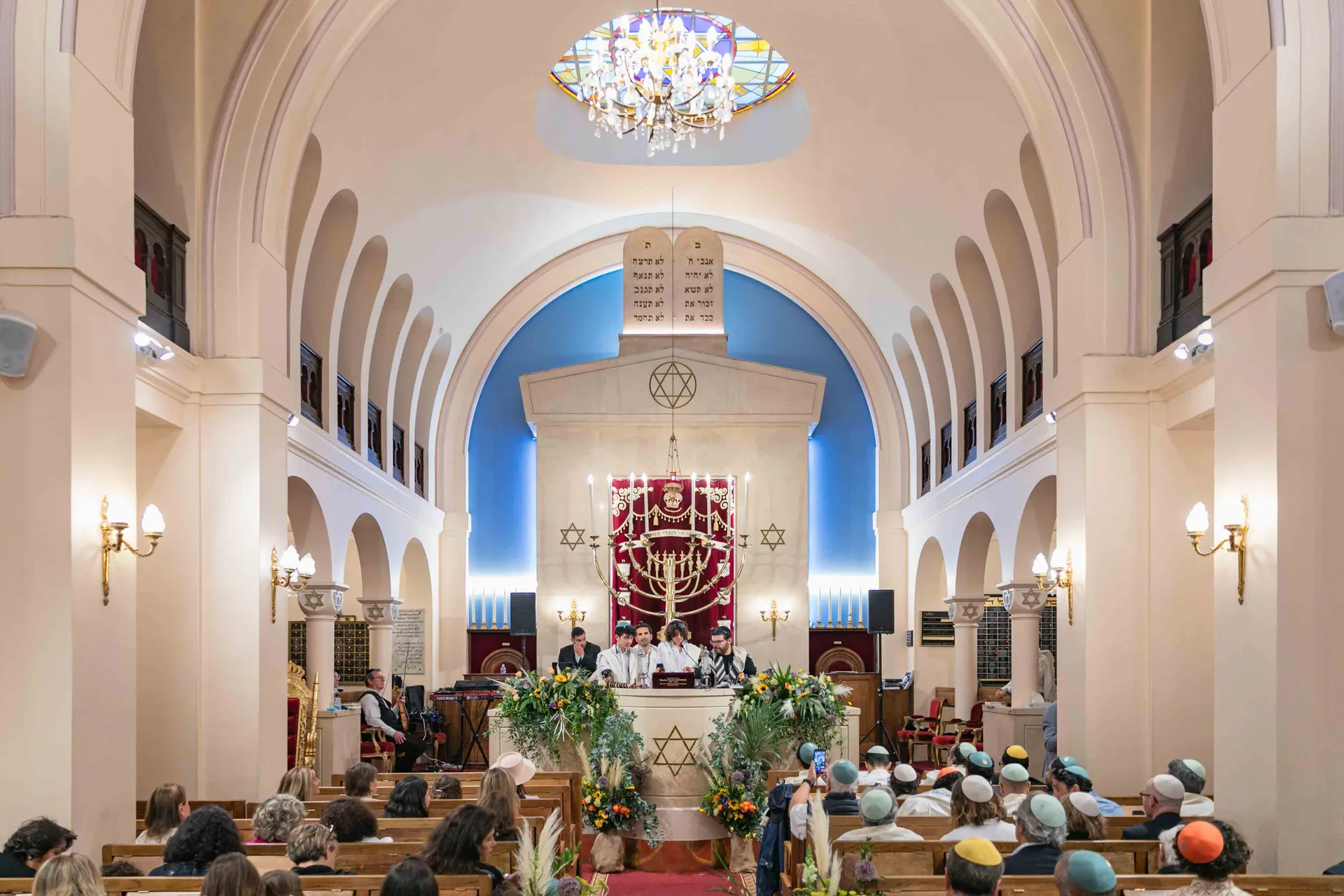 Vue d'ensemble de la synagogue parisienne pendant la cérémonie de Bar-Mitzvah, assemblée réunie sous les arcades
