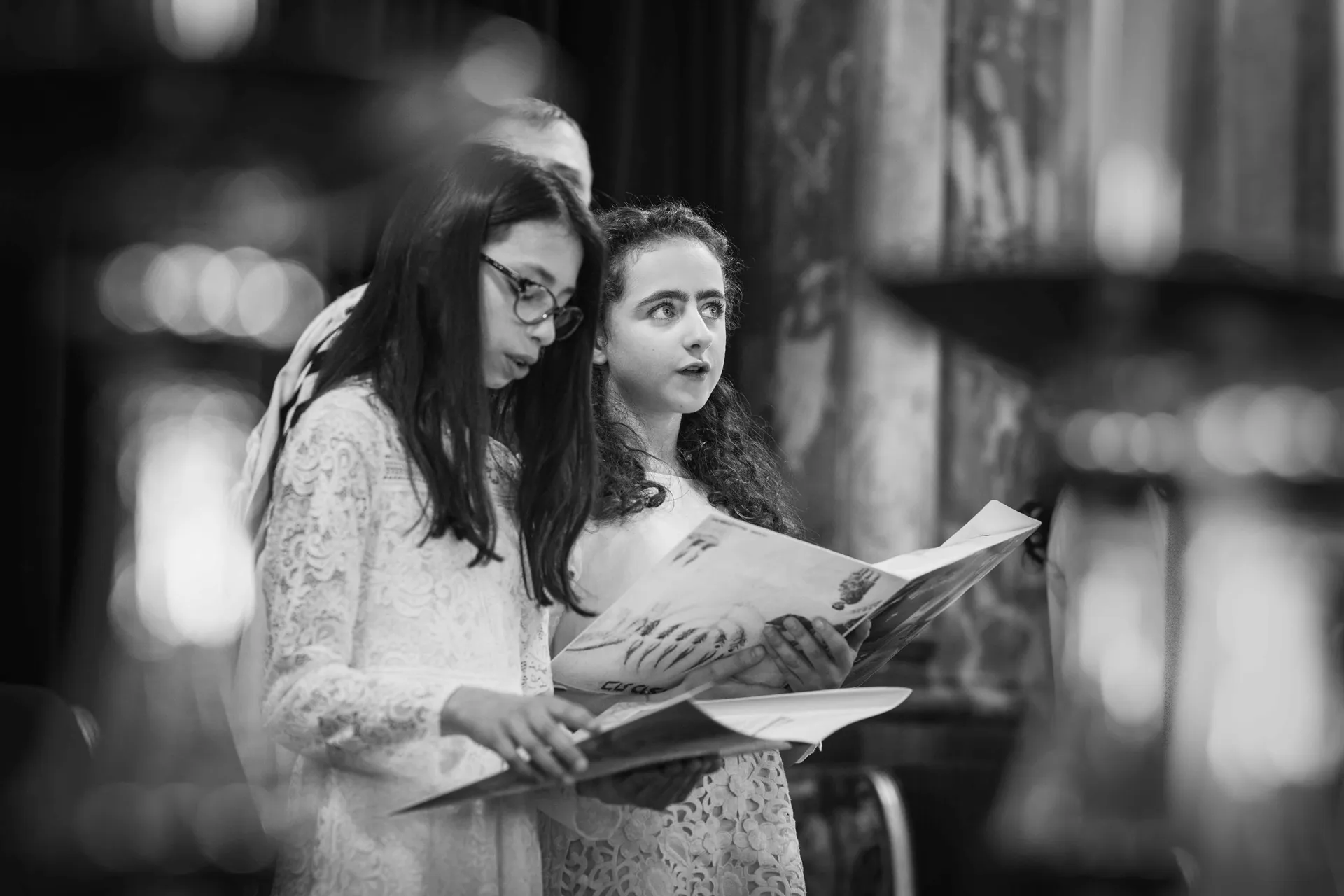 Deux jeunes filles lisant ensemble un livre de prières lors d'une Bat-Mitzvah dans une synagogue à Paris