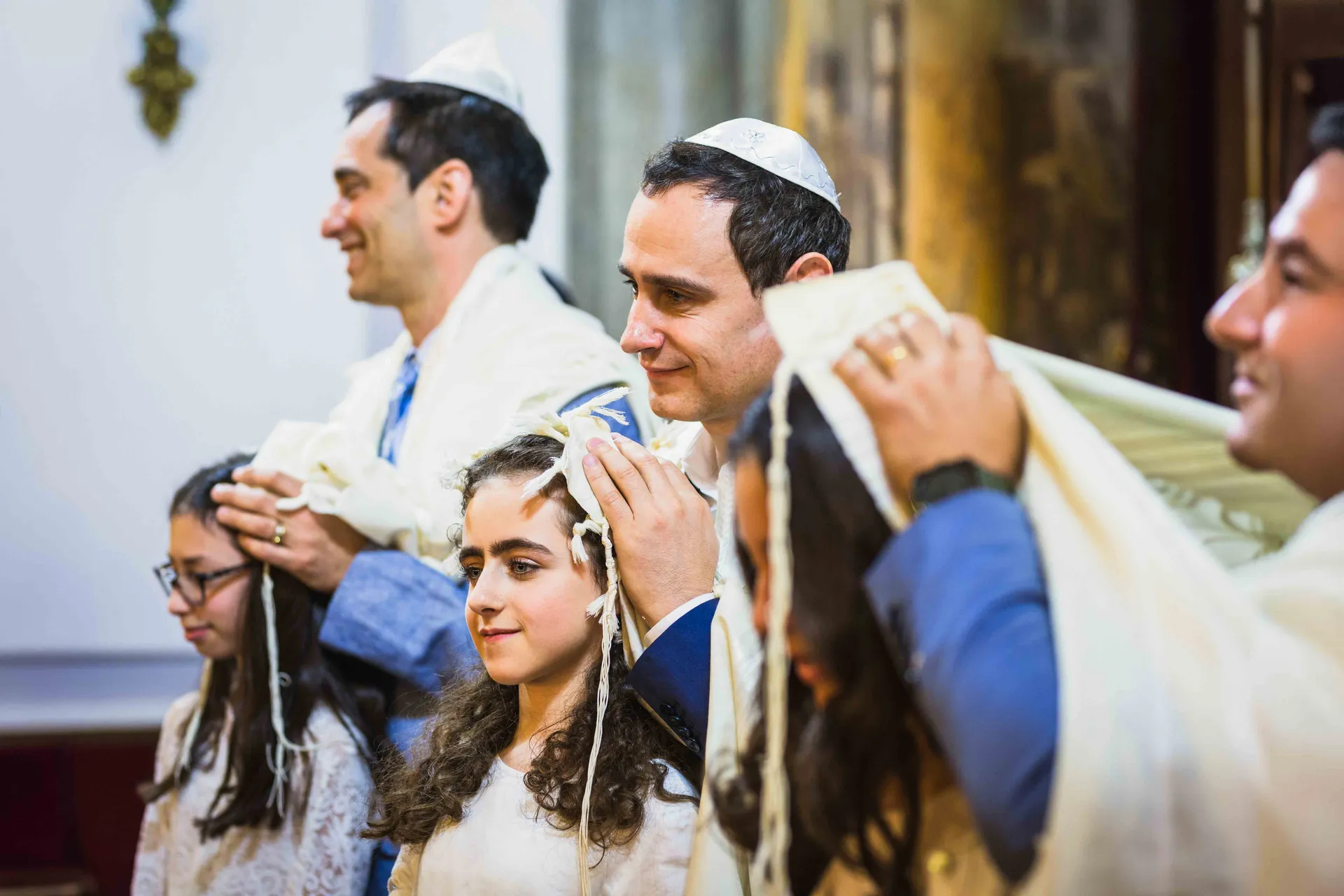 Famille debout pendant la bénédiction, portant le talith, lors d'une Bat-Mitzvah à Paris