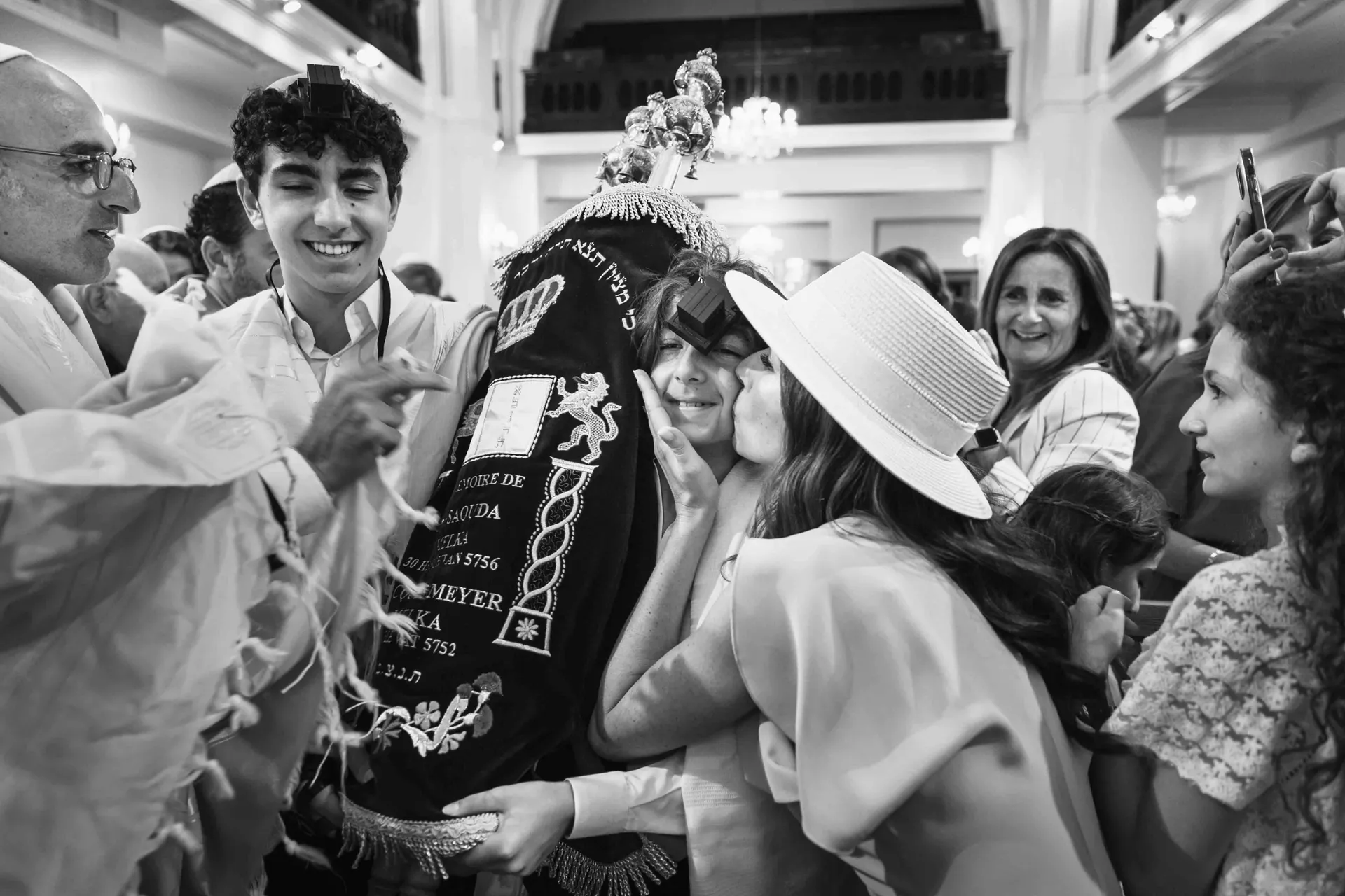 Le jeune Bar-Mitzvah portant le rouleau de la Torah entouré de l'assemblée, fin de cérémonie à Paris