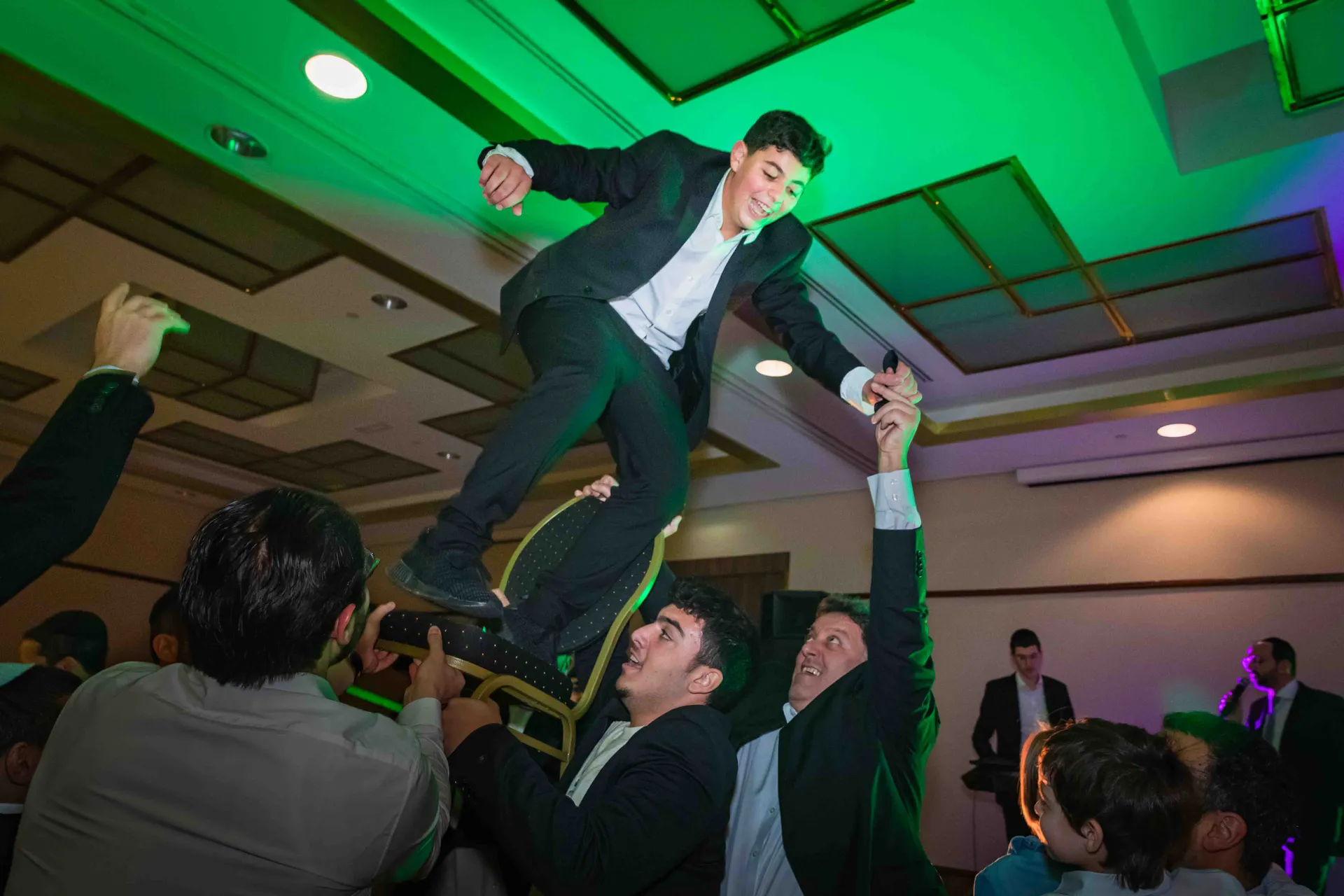 Jeune Bar-Mitzvah porté sur les épaules par les invités, ambiance festive en soirée à Paris