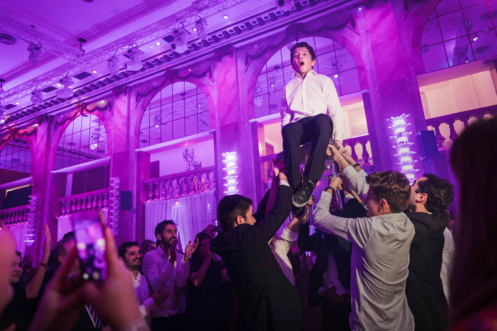Jeune garçon porté sur les épaules pendant la fête, réception de Bar-Mitzvah aux Salons Hoche à Paris