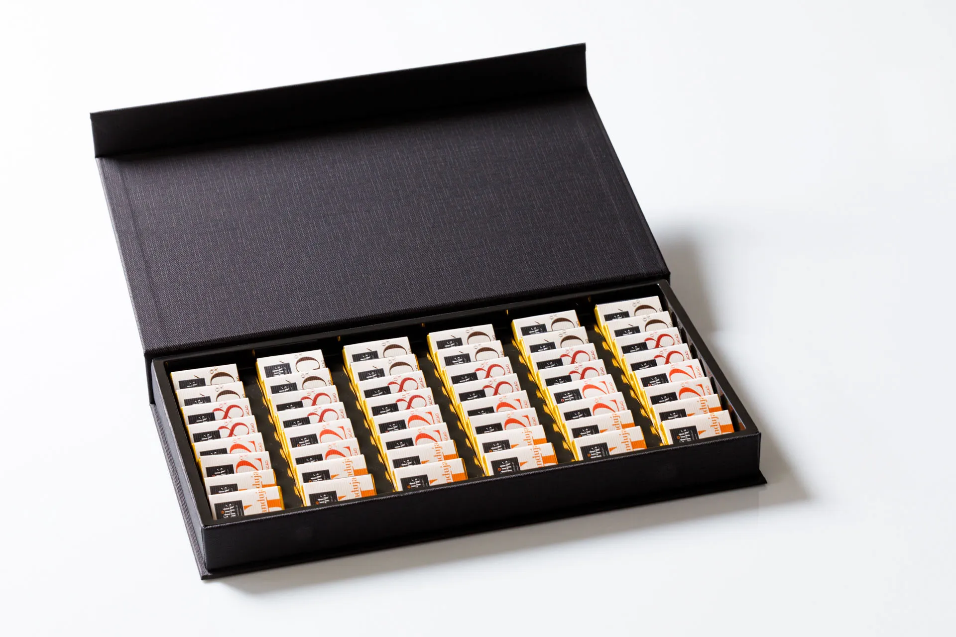 Coffret de chocolats Le Petit Carré de Chocolat, plusieurs rangées présentées dans un écrin noir
