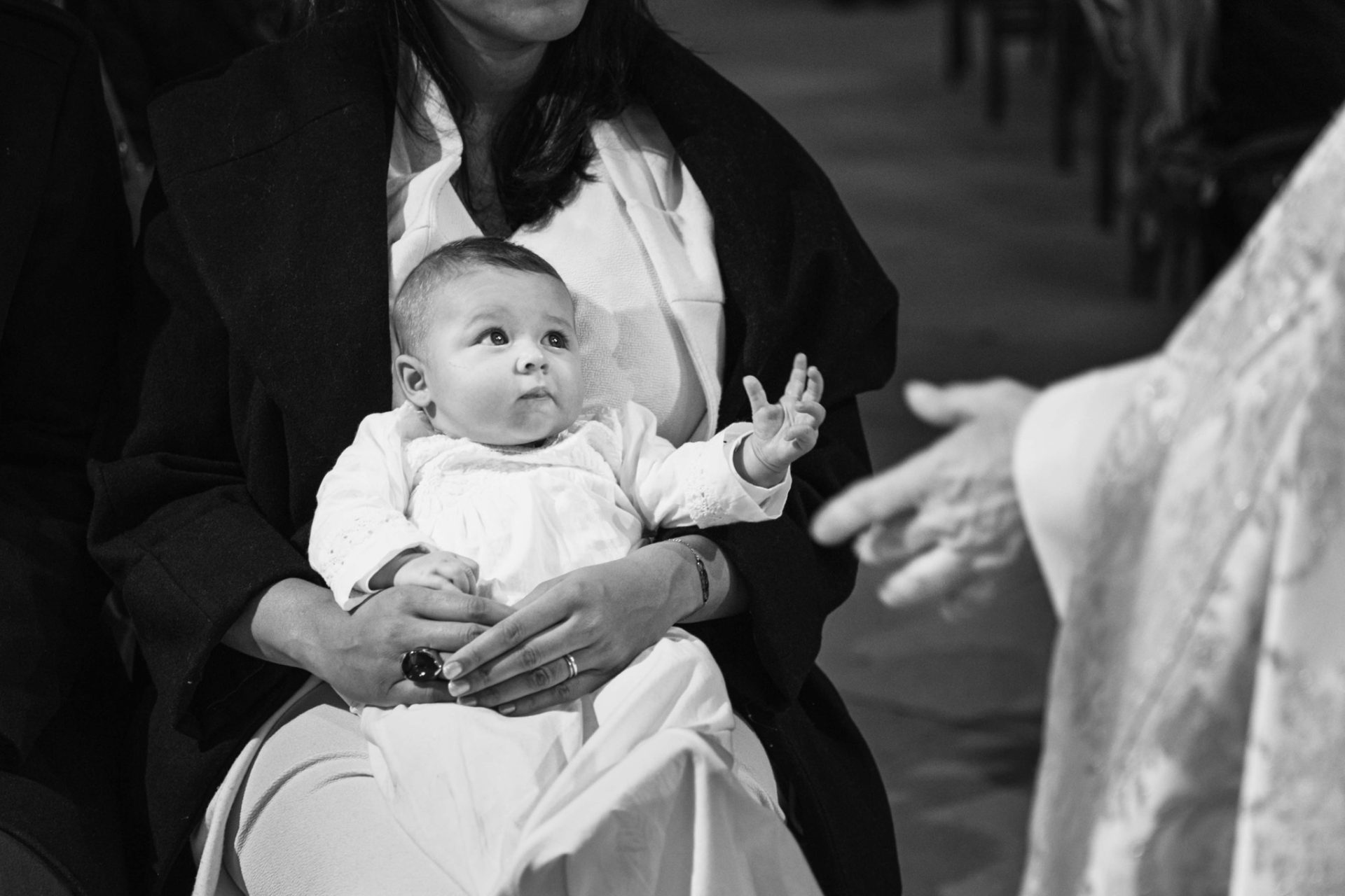 Bébé en robe de baptême porté dans les bras, cérémonie dans une église du 1er arrondissement de Paris